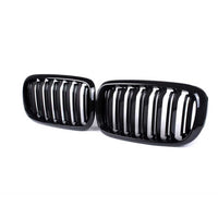 Set grile frontale duble BMW X5 F15 și BMW X6 F16 (2015–2018), design sportiv cu lamele verticale, material ABS rezistent, finisaj negru lucios, perspectivă laterală.