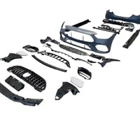 Componentele complete ale kitului exterior C63 AMG pentru Mercedes Clasa C W206, afișate din unghi frontal, inclusiv bară față, grilă, ornamente și elemente de montaj.
