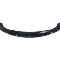 Prelungire bară față BRABUS pentru Mercedes-Benz E-Class W213 (2016-2019), piesă aftermarket din fibră de carbon, culoare negru lucios, vedere frontală pe fundal alb.