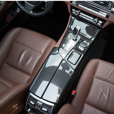 Vedere de sus a cotierăi centrale din fibră de carbon montată pe BMW Seria 5 F10. Design curbat, suprafață lucioasă, finisaj impecabil.